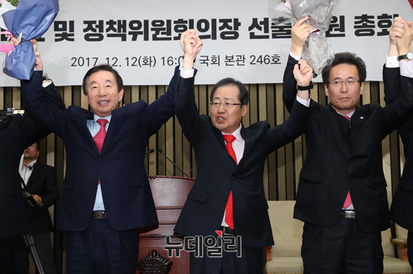 ▲ 자유한국당 홍준표 대표가 12일 오후 경선 결과가 전해진 직후 의총장에 도착해, 경선에서 승리한 김성태 원내대표~함진규 정책위의장과 손을 맞잡고 축하하고 있다. ⓒ뉴데일리 이종현 기자
