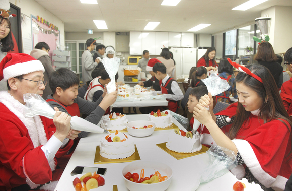 ▲ LG디스플레이 임직원들이 지난 21일 서울 지역아동센터를 방문해 선물을 전달하고 크리스마스케이크를 만드는 모습. ⓒLGD