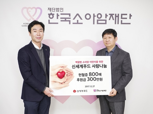 ▲ 27일 서울 중구 중림동 한국소아암재단에서 신세계푸드 김진규 CSR 팀장(왼쪽)이 한국소아암재단 홍승윤 사무국장에게 임직원들이 모은 헌혈증 800매와 후원금 300만원을 전달했다. ⓒ신세계푸드