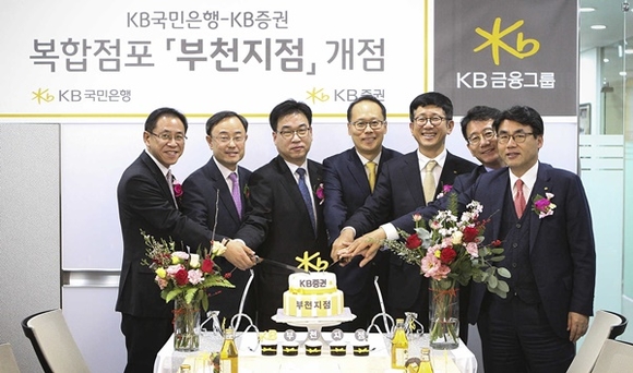 ▲ 지난 11일 진행된 KB GOLD& WISE 신중동종금센터(부천지점) 개점 행사에서 양재영 국민은행 부천지역영업그룹 대표(왼쪽 첫번째)와 이재형 KB증권 WM총괄본부장(오른쪽 세번째) 및 임직원들이 축하 케이크를 자르고 있다. ⓒKB금융지주