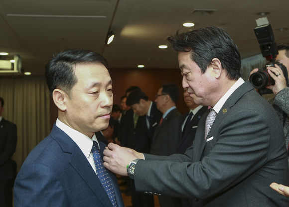 ▲ 코오롱 이웅열 회장이 2일 열린 시무식에서 '성장과 안정이라는 두 마리 토끼를 모두 잡자'는 의미의 'CATCH 2018' 배지를 신임 임원에게 달아주고 있다.  ⓒ코오롱