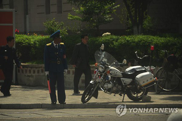 ▲ 北평양에서 교통정리 중인 사회보안원(경찰). 옆에 오토바이가 보인다. 북한에서는 과거 오토바이가 노동당 간부나 사회보안원 등만 탈 수 있는 것이어서 선망이 대상이 되기도 했다고 한다. ⓒ연합뉴스. 무단전재 및 재배포 금지.