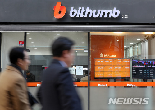 ▲ 서울 중구에 위치한 빗썸 거래소 전광판 앞을 시민들이 지나가고 있다. ⓒ뉴시스