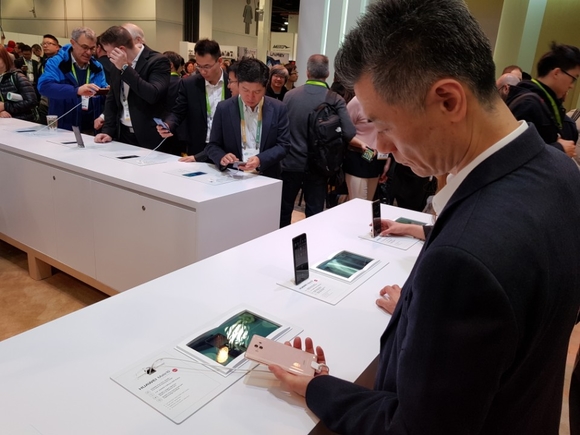 황정환 LG전자 MC사업본부장 부사장이 9일(현지시간) 미국 라스베이거스에서 열린 'CES 2018'에서 중국 화웨이 매장을 방문해 스마트폰을 살펴보고 있다. ⓒ연찬모 기자