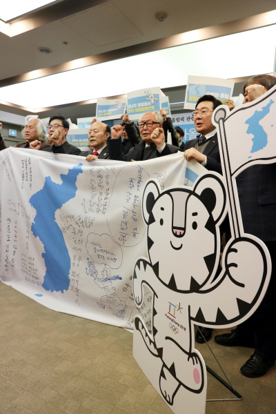 ▲ 6.15공동선언실천 남측위원회 상임대표 의장을 비롯한 참석자들이 11일 오전 서울 중구 프레스센터 기자회견장에서 열린 ‘남북고위급회담 결과 및 평창동계올림픽 관련 6.15 남북공동선언실천 남측위원회 기자회견’에서 대형 단일기(한반도기)를 들고 구호를 외치고 있다. ⓒ 뉴시스