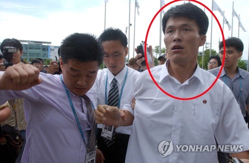 ▲ 2003년 8월 대구유니버시아드 대회로 방한한 김강국 조선중앙통신 기자가 국내 시민단체의 '북한 인권 고발' 집회에 항의하는 모습.ⓒ사진=연합뉴스