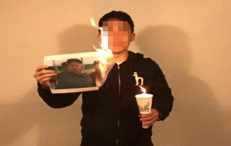 ▲ 한 20대 남성이 김정은 사진을 불태우고 있다. ⓒ페이스북 '왕국의 역습'