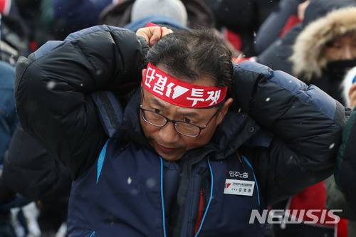 ▲ 30일 민주노총 '최저임금 인상 무력화 규탄' 결의대회에 앞서 김명환 위원장이 머리끈을 묶고 있다. ⓒ뉴시스