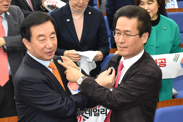▲ 자유한국당 김성태 원내대표(왼쪽)와 함진규 정책위의장이 평창
 동계올림픽을 응원하기 위해 태극기 배지를 달아주고 있다. ⓒ뉴데일리 이종현 기자