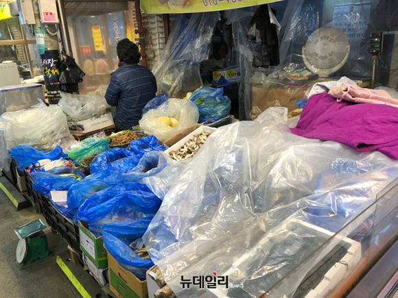 ▲ 추운 날씨에 비닐로 상품을 가려 놓은 상인. ⓒ진범용 기자