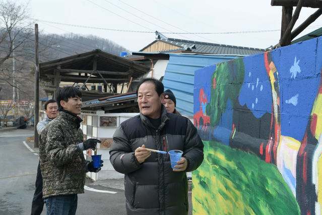 ▲ 김영석 영천시장이 지난 9~12일 화산면 가상리 ‘가래실 문화마을’에서 열린 경북대학교 총동아리연합회 동계벽화 봉사활동에 참가해 직접 벽화를 그려보고 있다.ⓒ영천시