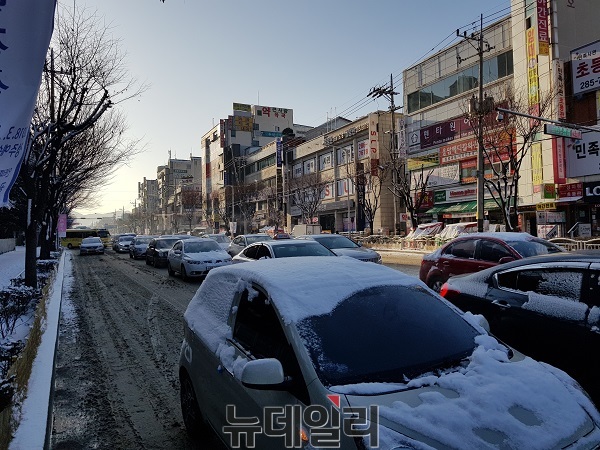 ▲ 12일 아침 충북 청주시 상당구 중흥로 인근 대로변에는 출근에 나선 승용차들이 밤새 내린 폭설로 거북이 운행을 하고 있다.ⓒ김정원 기자