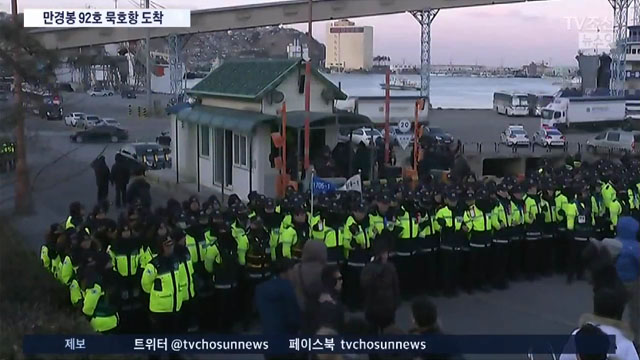 ▲ 지난 6일 'TV조선'이 만경봉 92호 입항 상황을 중계보도하는 영상. 뒷편으로 지나가는 흰색 탑차 트럭들이 보인다. ⓒTV조선 관련보도 화면캡쳐.