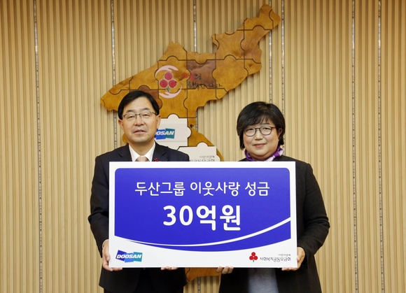 ▲ (왼쪽)박완석 ㈜두산 부사장이 김연순 사회복지공동모금회 사무총장에게 성금을 전달하고 기념촬영을 하고 있는 모습.ⓒ두산