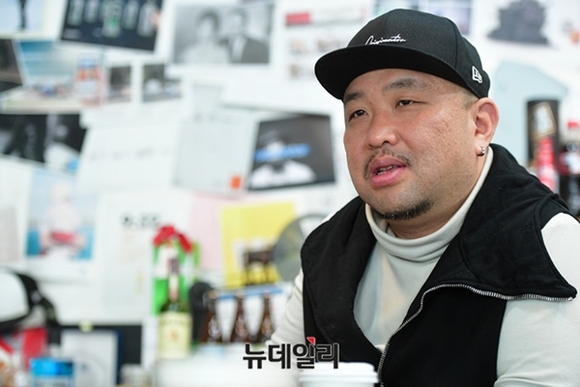 ▲ 대표실에 앉아있는 전훈철 애드쿠아 대표. 사무실 벽에는 해외 광고 이미지가 가득히 붙어 있다. ⓒ정상윤 기자