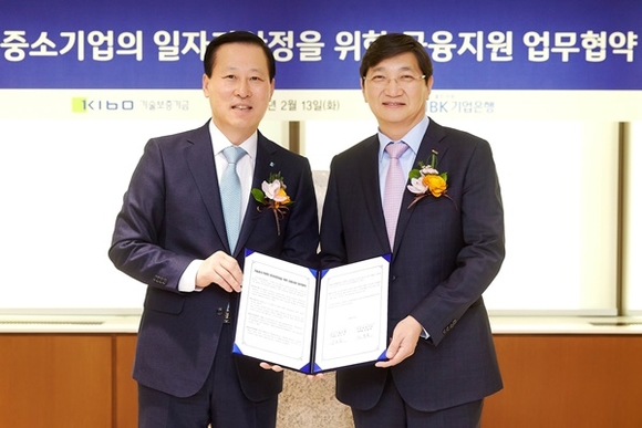 ▲ 김도진 기업은행장(왼쪽)과 김규옥 기술보증기금 이사장이 기업은행 본점에서 협약식을 마치고 기념촬영을 하고 있다. ⓒIBK기업은행