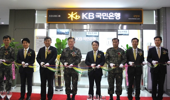 ▲ KB국민은행은 지난 13일 국방부 내 합동참모본부 청사에서 전담영업점 개점 행사를 가졌다. 왼쪽 세번째부터 국민은행 김환국 중앙지역영업그룹대표, 합동참모본부 원인철 군사지원본부장, 국민은행 오평섭 영업그룹대표, 합동참모본부 오원진 인사부장. ⓒKB국민은행