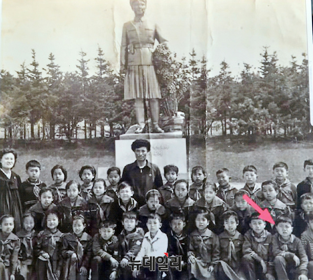 ▲ 9살 때 지성호 대표의 모습(화살표). 김일성의 부인 김정숙 동상 앞에서 찍은 단체사진이다. 북한은 김씨 왕조라면 뭐든 우상화하는 버릇이 있다. ⓒ공준표 뉴데일리 기자- NAUH 제공