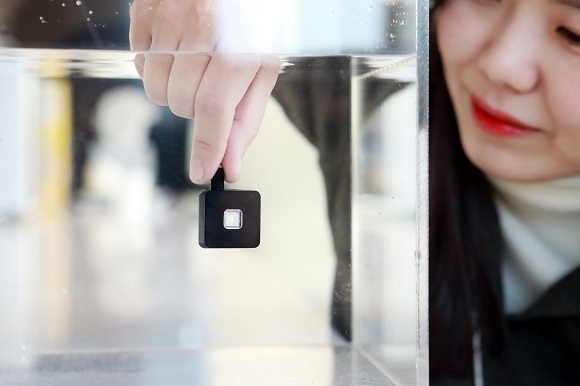 ▲ LG이노텍 직원이 방수 기능을 갖춘 정수기 살균용 UV LED 모듈을 물 속에 넣어 살펴보고 있다. ⓒLG이노텍