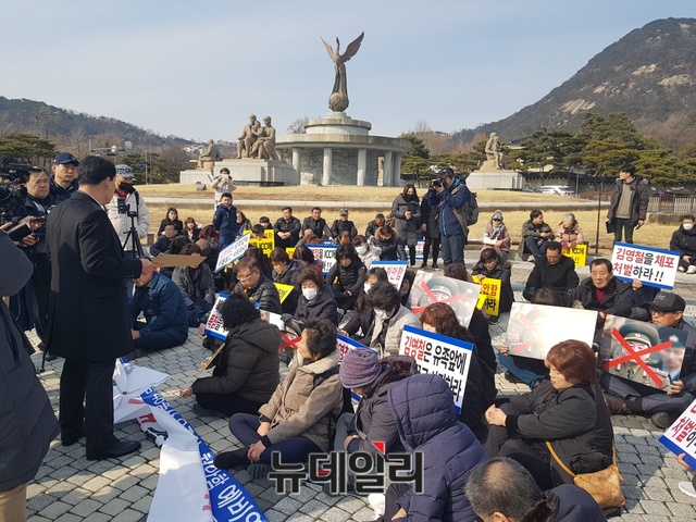 24일 천안함 유족들이 '북한 김영철 방한에 대한 천안함 46용사 유가족과 생존 장병의 입장' 서한을 전달하기 위해 청와대 앞 광장을 찾은 모습. 대기 시간이 길어지자 유족들은 바닥에 앉아 