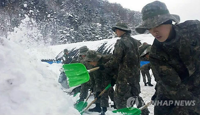 ▲ 2014년 2월 폭설이 내린 강원도 인제군 일대에서 민간 제설작업을 대민지원 중인 3군단 장병들. 해당 지역 주민들은 이들에게 '일당'을 지불한 적이 없다. ⓒ연합뉴스. 무단전재 및 재배포 금지.