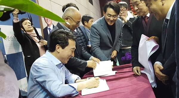 ▲ 충남지사 선거에 출마한 박수현 예비후보가 최근 천안에서 열린 출판기념회에서 지지자들에게 줄 자신의 저서에 사인을 하고 있다.ⓒ박수현 예비후보 사무실