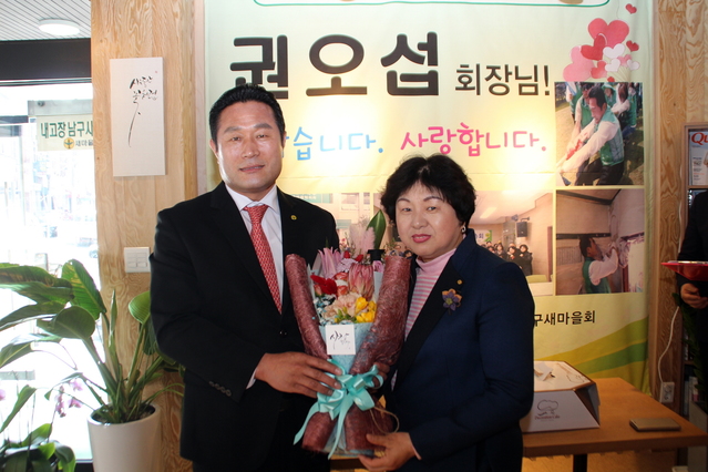 ▲ 대구 남구청장 출마예정인 권오섭 남구새마을회장(왼쪽)이 회원 대표에게 꽃다발을 받은 뒤 기념사진을 찍고 있다.ⓒ권 예정자
