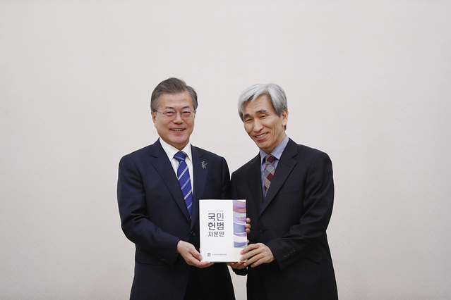 ▲ 문재인 대통령과 정해구 국민헌법 자문특별위원회 위원장. 책은
 자문위원회가 작성한 헌법 초안으로 알려졌다. ⓒ청와대 제공