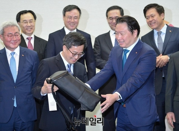 ▲ 김동연 부총리(왼쪽)가 최태원 SK 회장(오른쪽)으로부터 사회적 기업 '모어댄'에서 만든 가방을 건네 받고 있다.ⓒ공준표 기자