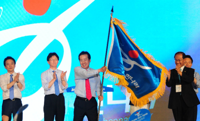 ▲ 자유한국당 홍준표 대표가 2011년 7월 4일 열린 한나라당 7·4 전당대회에서 대표최고위원으로 선출된 뒤, 당기를 흔들고 있다. 뒷쪽으로 친박계의 집중지원을 받았는데도 차점자로 밀린 바른미래당 유승민 대표의 씁쓸한 표정이 보인다. ⓒ뉴시스 사진DB