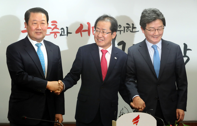 ▲ 홍준표(가운데) 자유한국당 대표가 1월 23일 서울 영등포구 여의도 자유한국당 당사를 예방한 바른미래당 박주선(왼쪽), 유승민 공동대표의 손을 잡고 기념촬영을 하고 있다. ⓒ뉴시스