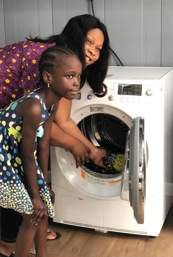 ▲ 현지 주민이 LG워시하우스에서 건조기를 체험해보고 있는 모습. ⓒLG전자