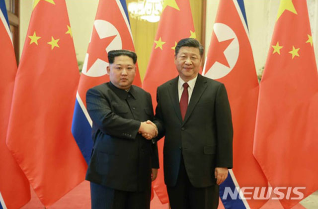 지난 3월 25일 김정은과 시진핑 中국가주석이 만나 악수하는 모습. 김정은은 방중 기간 동안 '단계적 비핵화'를 주장했다. ⓒ뉴시스. 무단전재 및 재배포 금지.