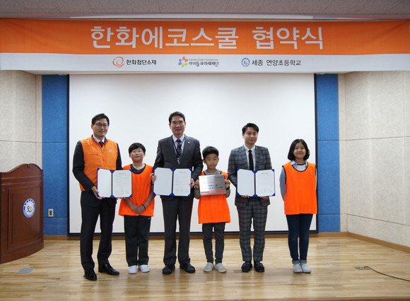 ▲ 한화첨단소재 김종남 세종사업장장(왼쪽 끝)과 연양초등학교 엄창섭 교장(왼쪽에서 세 번 째), 아이들과 미래 정준용 팀장이 5일 세종시 연양초등학교에서 진행된 '2018 한화에코스쿨 프로그램' 협약식 후 기념촬영하고 있다. ⓒ 한화첨단소재