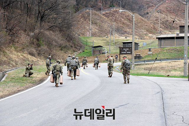 ▲ 액체가 가득한 통을 들고 가파른 언덕을 오르는 체력 검정중인 대회 참가자들 ⓒ뉴데일리 오세진