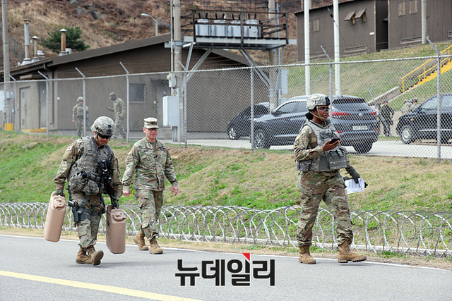 ▲ 액체가 가득한 통을 들고 가파른 언덕을 오르는 체력 검정중인 대회 참가자들 ⓒ뉴데일리 오세진