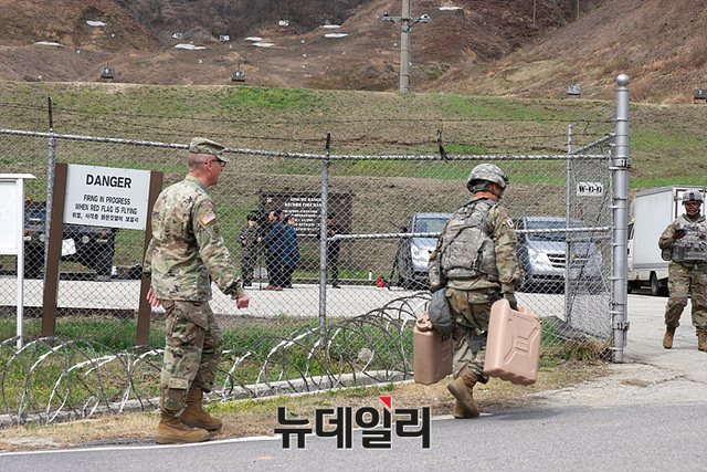 ▲ 액체가 가득한 통을 들고 가파른 언덕을 오르는 체력 검정중인 대회 참가자들 ⓒ뉴데일리 오세진