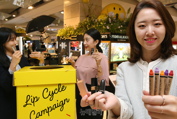 ▲ 현대백화점 압구정본점에 비치된 립스틱 수거함 앞에서 직원들이 '립사이클 캠페인'을 소개하고 있다.  ⓒ현대백화점
