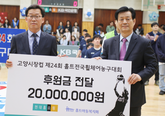 ▲ 경기도 고양시 홀트아동복지회 종합체육관에서 임대규 현대홈쇼핑 부사장(사진 왼쪽)과 김대열 홀트아동복지회 회장(사진 오른쪽)이 ‘제 24회 홀트전국휠체어 농구대회’ 개막식에서 후원금을 전달하고 기념촬영을 하고 있는 모습. ⓒ현대홈쇼핑