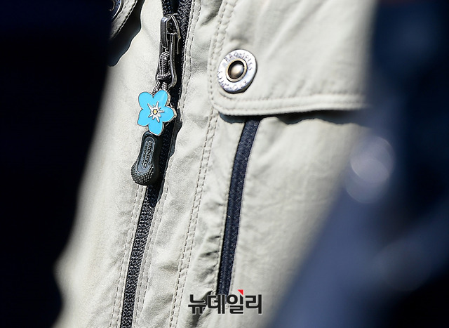 ▲ 납북피해가족들이 가슴에 달고 있는 물망초 배지.ⓒ뉴데일리 정상윤 기자