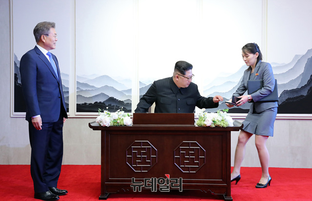 ▲ 방명록을 적기 위해 김여정에게 펜을 받는 김정은과 이를 지켜보는 문재인 대통령. ⓒ한국공동사진기자단.