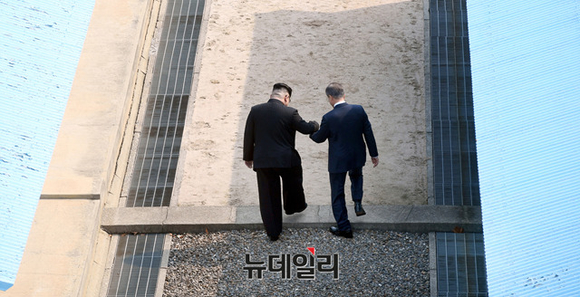 ▲ 문재인 대통령(오른쪽)과 북한 김정은이 27일 판문점에서 만나 군사분계선을 넘고 있다. ⓒ한국공동사진기자단