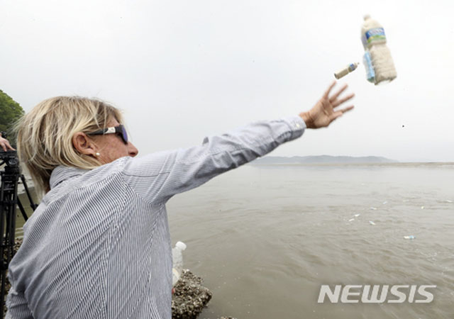 ▲ 지난 1일 인천 강화도 석모도 삼산면 해변에서 쌀과 달러를 담은 페트병을 바다로 던지는 美인권단체 관계자. ⓒ뉴시스. 무단전재 및 재배포 금지.