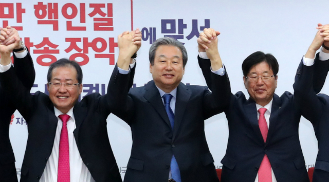 ▲ 홍준표 대표와 강길부 의원이 자유한국당 복당 직후인 지난해 11월 복당 의원 간담회에서 손을 맞잡고 있다. ⓒ뉴시스 사진DB