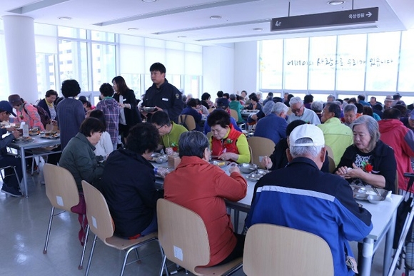 ▲ 교촌에프앤비 임직원 봉사단이 수원시 광교노인복지관에서 진행한 어버이날 기념 행사에서 어르신들에게 식사를 대접하고 있다ⓒ교촌에프앤비