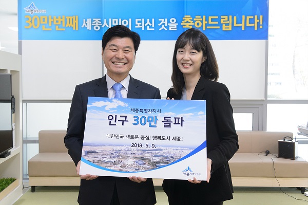 ▲ 이춘희 세종시장이 9일 세종시 새롬동 주민센터에서 30만번째 시민인 김지선씨에게 인정서와 꽃다발을 전달하고 있다.ⓒ세종시