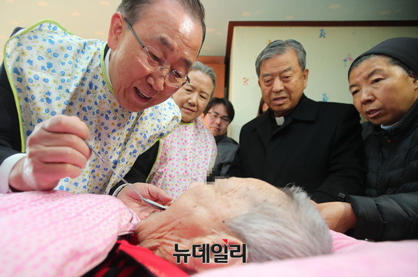 ▲ 지난해 1월 14일 반기문 전 유엔사무총장이 충북 음성군 맹동면에 위치한 사회복지시설 꽃동네를 찾아 요양 중인 할머니에게 죽을 떠 먹여드리고 있다. (왼쪽부터 반 전 총장, 부인 유순택 여사, 오웅진 신부, 윤숙자 시몬 수녀) ⓒ 정상윤 기자