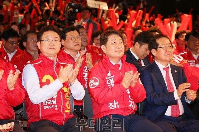 ▲ 이철우 한국당 경북도지사 후보와 권영진 후보, 홍준표 당 대표(왼쪽부터)가 결의대회 행사장에 나란히 앉아 박수를 치고 있다.ⓒ뉴데일리