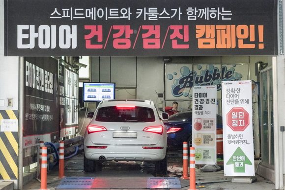 ▲ 운전자가 차 안에서 타이어 검진 결과를 모니터로 확인하고 있는 모습. ⓒSK네트웍스