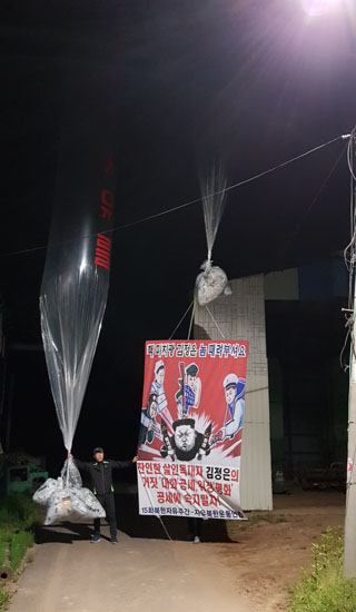 ▲ 자유북한운동연합(대표 박상학)은 12일 자정 무렵 경기 파주시에서 대북전단 15만 장을 살포했다고 밝혔다. 사진은 대북전단 살포 전 현수막을 보이는 모습. ⓒ자유북한운동연합 제공.